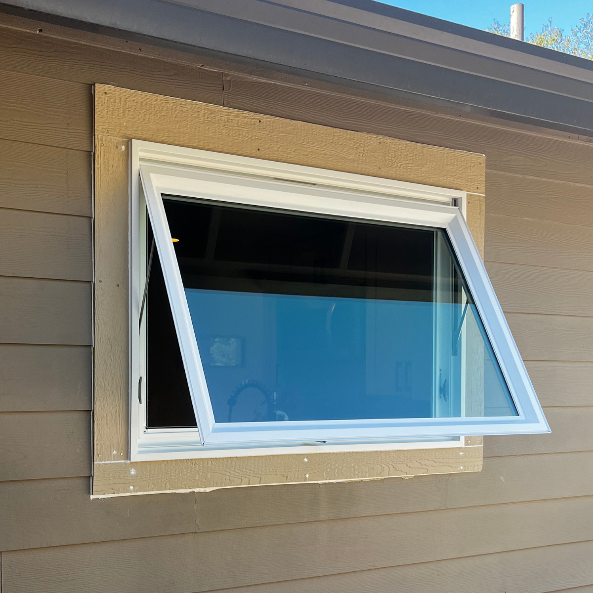 White awning window on a taupe exterior wall