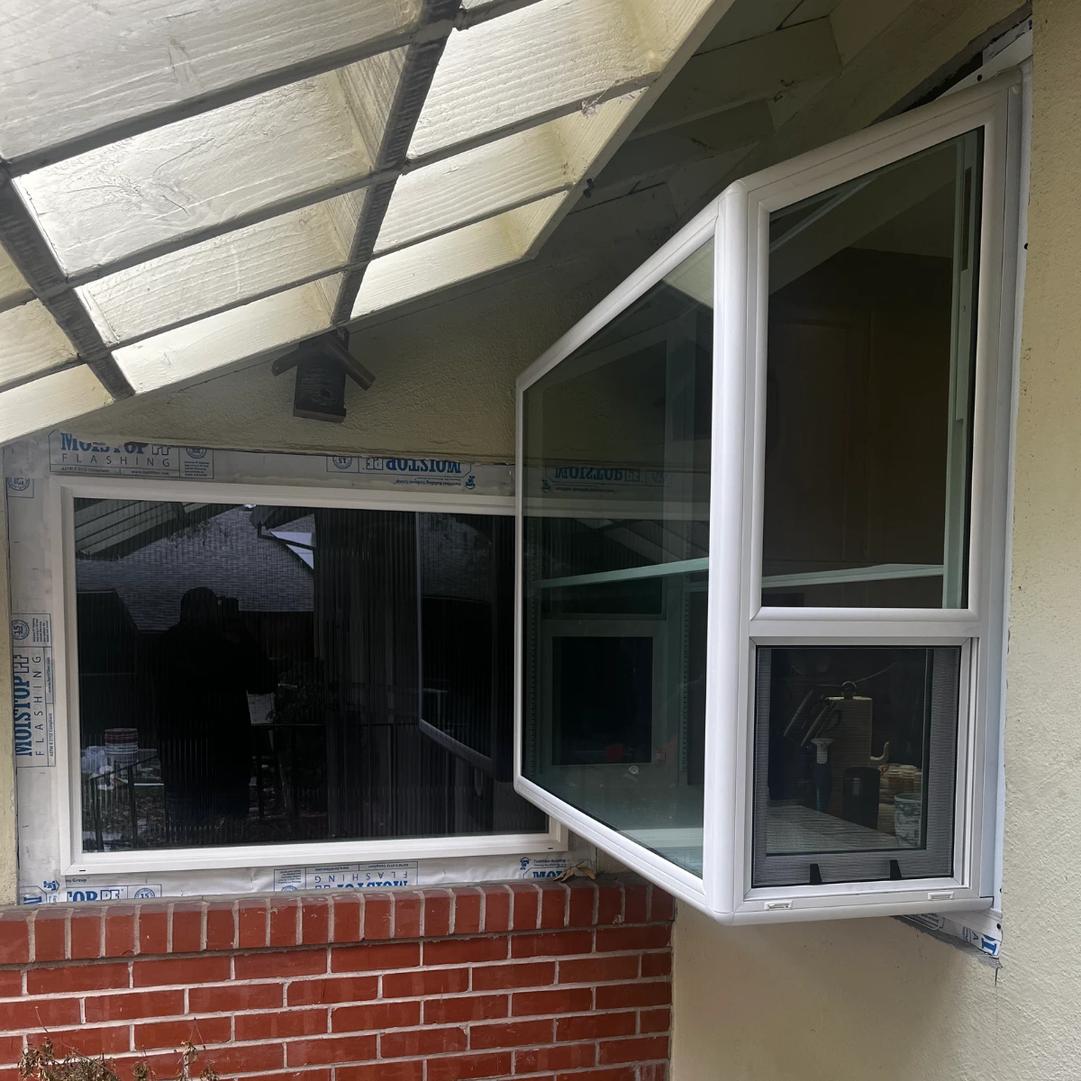 Open awning window on brick wall